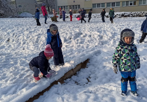 Dzieci bawią się w ogrodzie przedszkolnym na śniegu